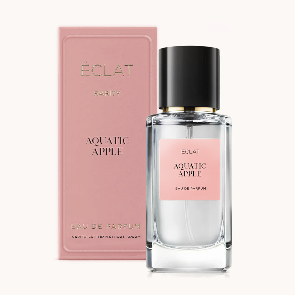 Ein facettierter Glasflakon von ÉCLAT Aquatic Apple mit schwarzem Verschluss, begleitet von einer rosafarbenen Box mit eleganter Markenprägung.