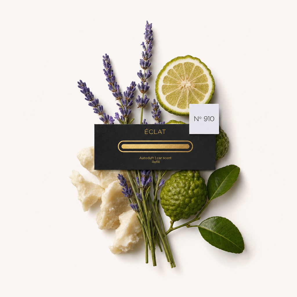 Ein Arrangement aus Lavendelzweigen, einer Bergamottenscheibe und grünen Blättern umgibt eine schwarze Verschlusskappe mit ÉCLAT-Etikett, gekennzeichnet mit Nr. 910.