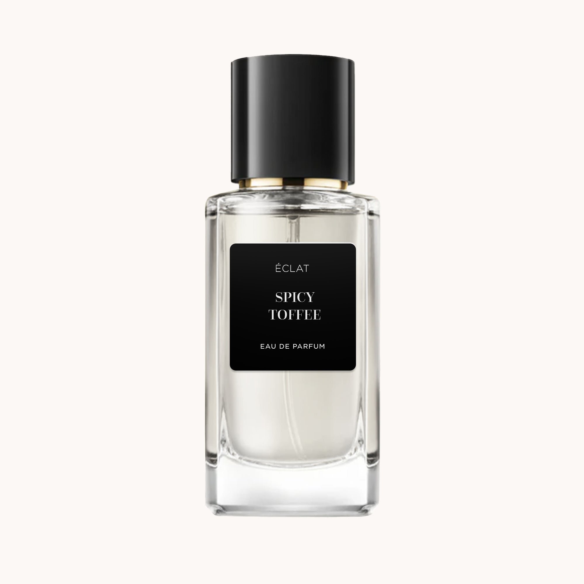 Das Parfum ÉCLAT Spicy Toffee zeigt einen klaren, facettierten Glasflakon mit mattem schwarzen Etikett und eleganter schwarzer Kappe.