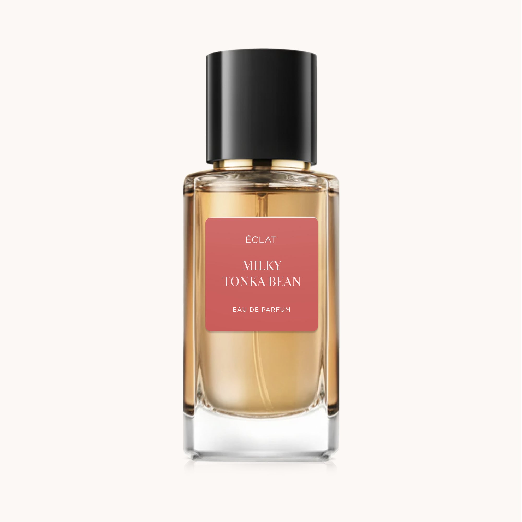 Facettierter Glasflakon mit schwarzem Verschluss und ÉCLAT Milky Tonka Bean Etikett auf einem weichen Hintergrund.