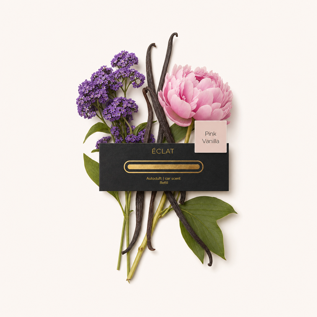 Ein Bündel aus lila Blumen, rosa Pfingstrose und dunklen Vanilleschoten umgibt eine schwarze Kappe mit ÉCLAT-Etikett und 'Pink Vanilla'.