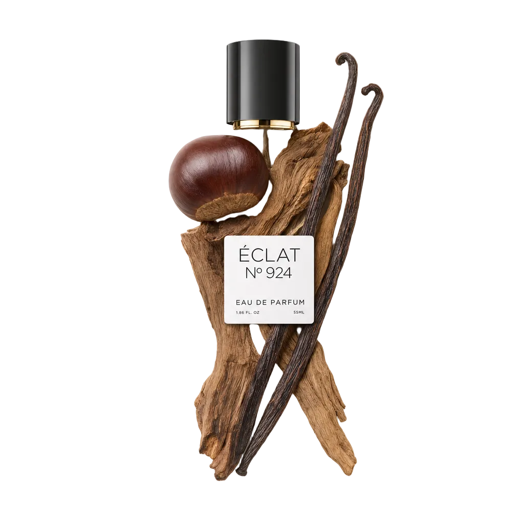 Ein künstlerisches Arrangement von ÉCLAT Smoky Chestnut umfasst eine glänzende schwarze Kappe mit goldfarbenem Akzent, eine ganze Kastanie, duftende Vanilleschoten und strukturierte Holzelemente.