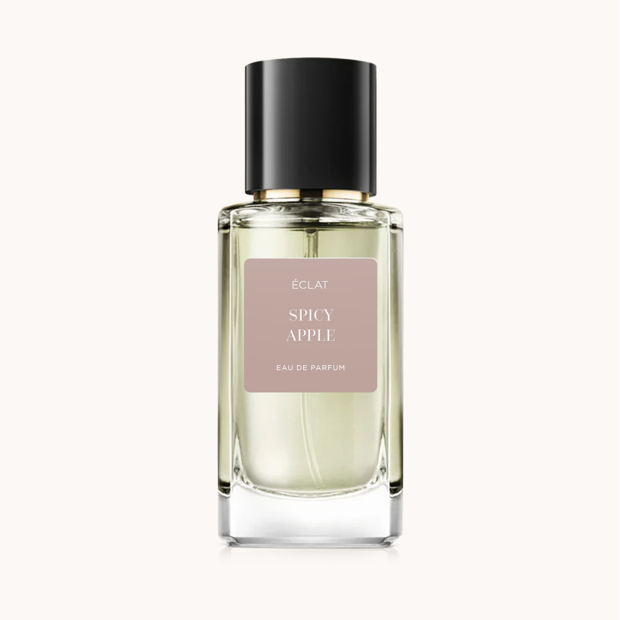 Facettierter Glasflakon von ÉCLAT Spicy Apple mit eleganter schwarzer Kappe, versehen mit mattem Etikett auf hellbeigem Hintergrund.