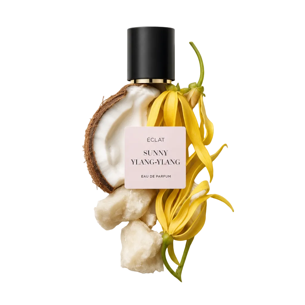 Ein Arrangement aus frischen Ylang-Ylang-Blüten, halber Kokosnuss und Stücken von Sheabutter, mit einer schwarzen Kappe mit ÉCLAT Sunny Ylang-Ylang Etikett.