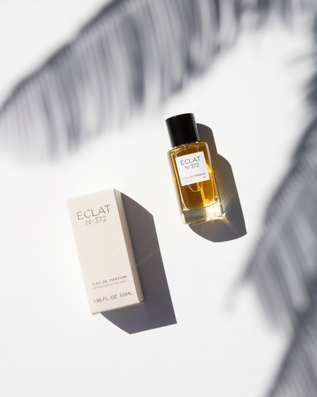 ÉCLAT 372 women’s perfume with palm leaf shadows in the background – key visual of the ÉCLAT Summer Collection for women 2025, evoking a feminine and tropical summer vibe.