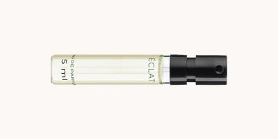 Ein zylindrisches Glasfläschchen mit schwarzem Sprühkopf, beschriftet mit ÉCLAT, enthält 5 ml Parfum.