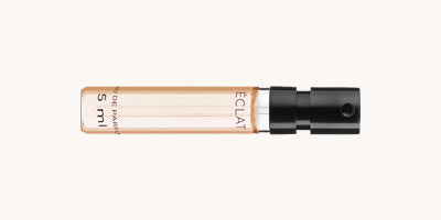 Ein klarer ÉCLAT Parfumflakon mit schwarzer Sprühdüse, der 5 ml Duft enthält.