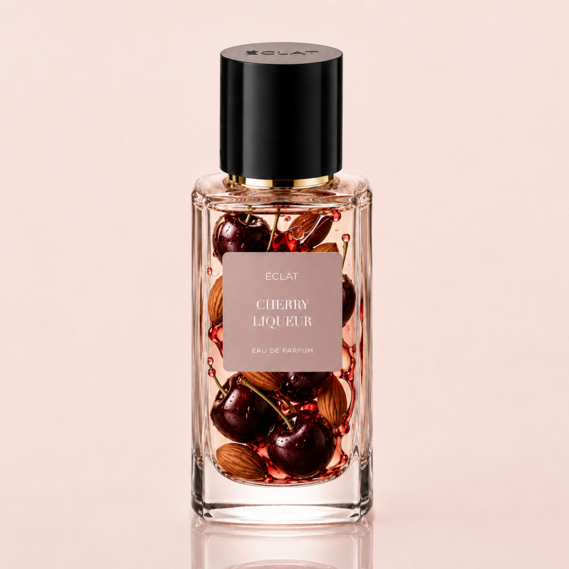 Facettierter Glasflakon von ÉCLAT Cherry Liqueur Eau de Parfum mit schwarzer Kappe und einem Etikett mit Kirschen und Mandeln.
