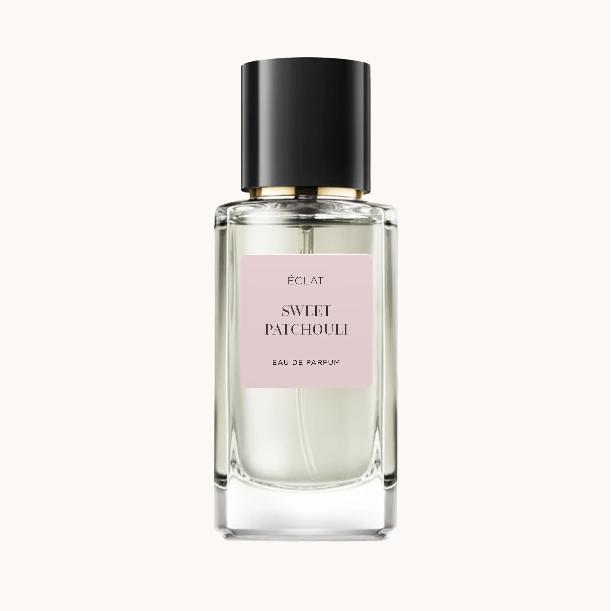 Ein facettierter Glasflakon von ÉCLAT Sweet Patchouli mit schwarzer Kappe und einem sanft rosa Etikett.