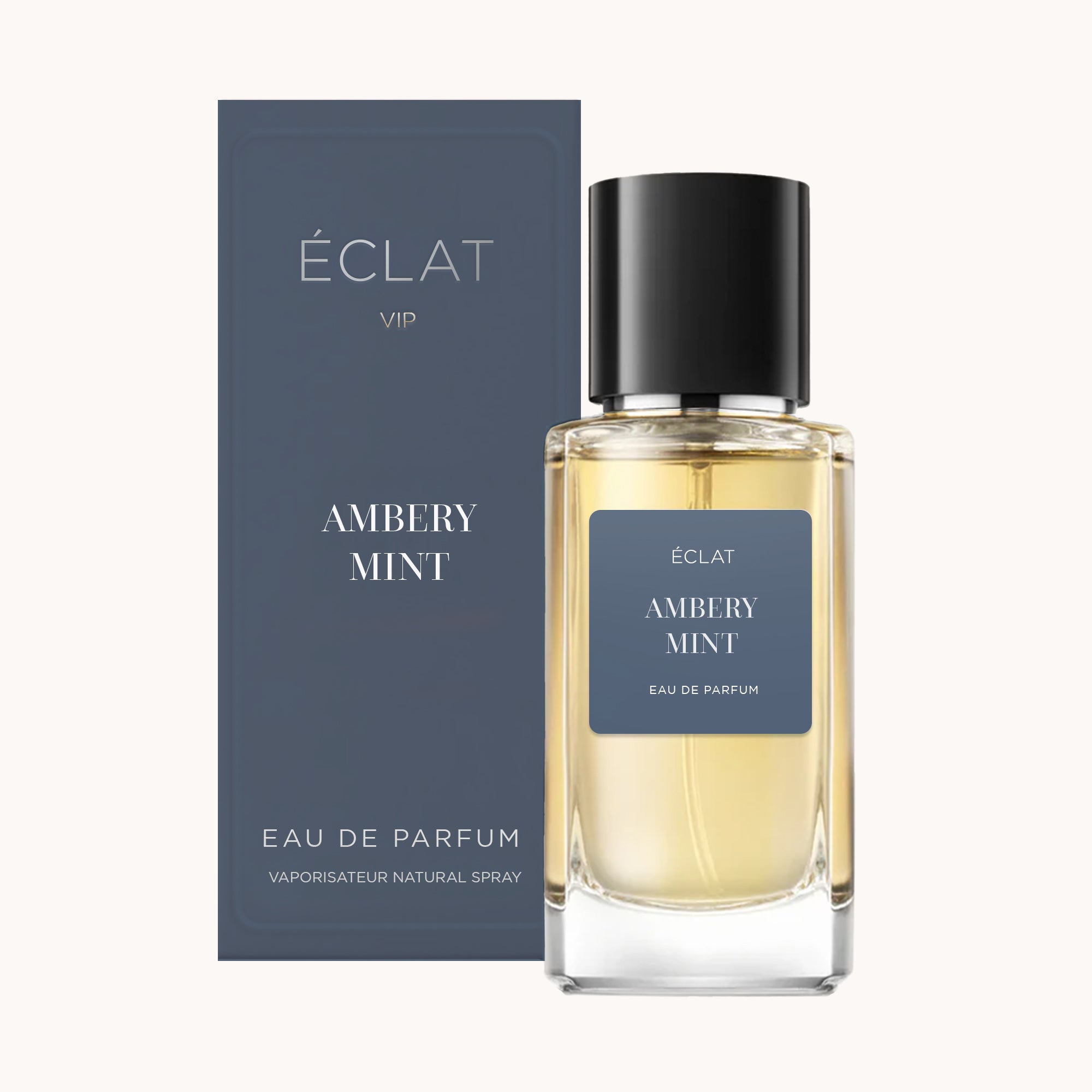 Das ÉCLAT Ambery Mint VIP Parfum ist in einem klaren Glasflakon mit schwarzem Verschluss und passender dunkelblauer Schachtel präsentiert.