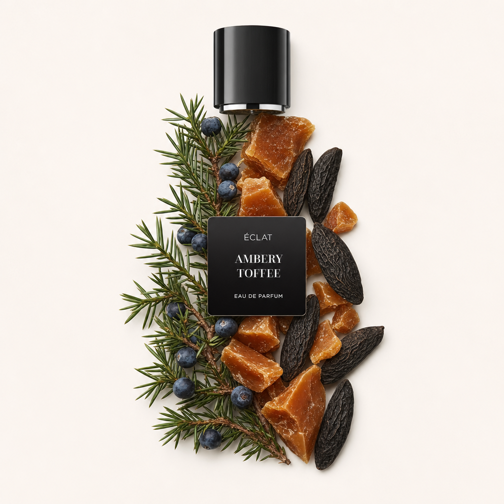 Ein Arrangement aus Ambery-Toffee-Stücken, Tonkabohnen und Wacholderzweigen umgibt eine schwarze ÉCLAT-Kappe mit Etikett.