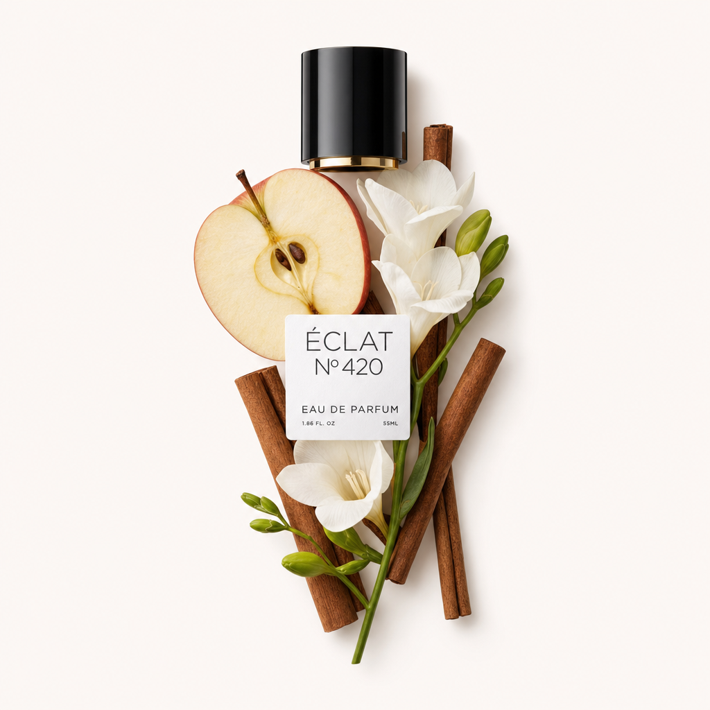 Ein sorgfältig arrangiertes Stillleben aus Apfelscheiben, Zimtstangen und weißen Blumen um eine schwarze Kappe mit ÉCLAT Apple & Cinnamon Etikett.