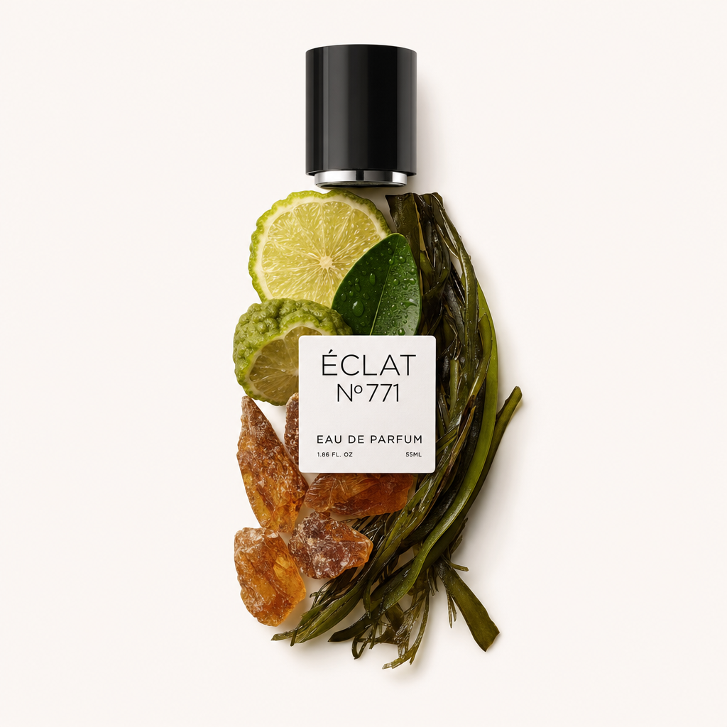 Ein von Hand arrangiertes Stillleben der ÉCLAT Aquatic Ambroxide Zutaten mit Limettenscheiben, Olivenblättern, Amberkristallen und Algen, oben eine schwarze Kappe und ein Etikett.