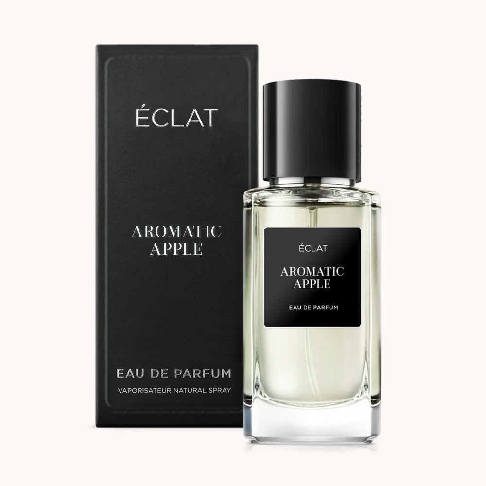 Ein klarer Glasflakon von ÉCLAT Aromatic Apple mit schwarzem Etikett und Verschluss, begleitet von einer eleganten schwarzen Box.