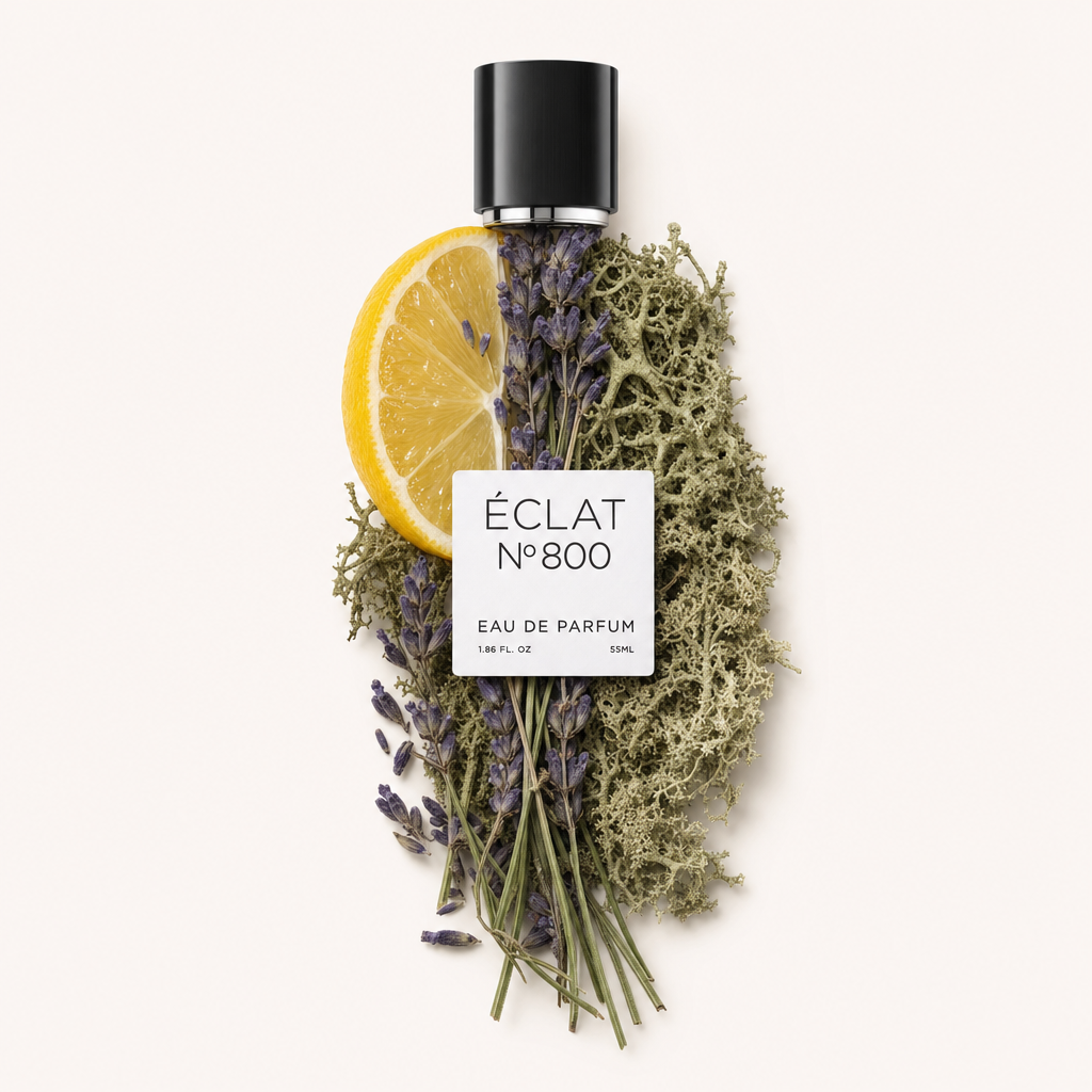 Ein Arrangement aus einer Zitronenscheibe, Lavendelzweigen und Eichenmoos umgibt die originale schwarze Kappe mit ÉCLAT Aromatic Oak Moss Etikett.
