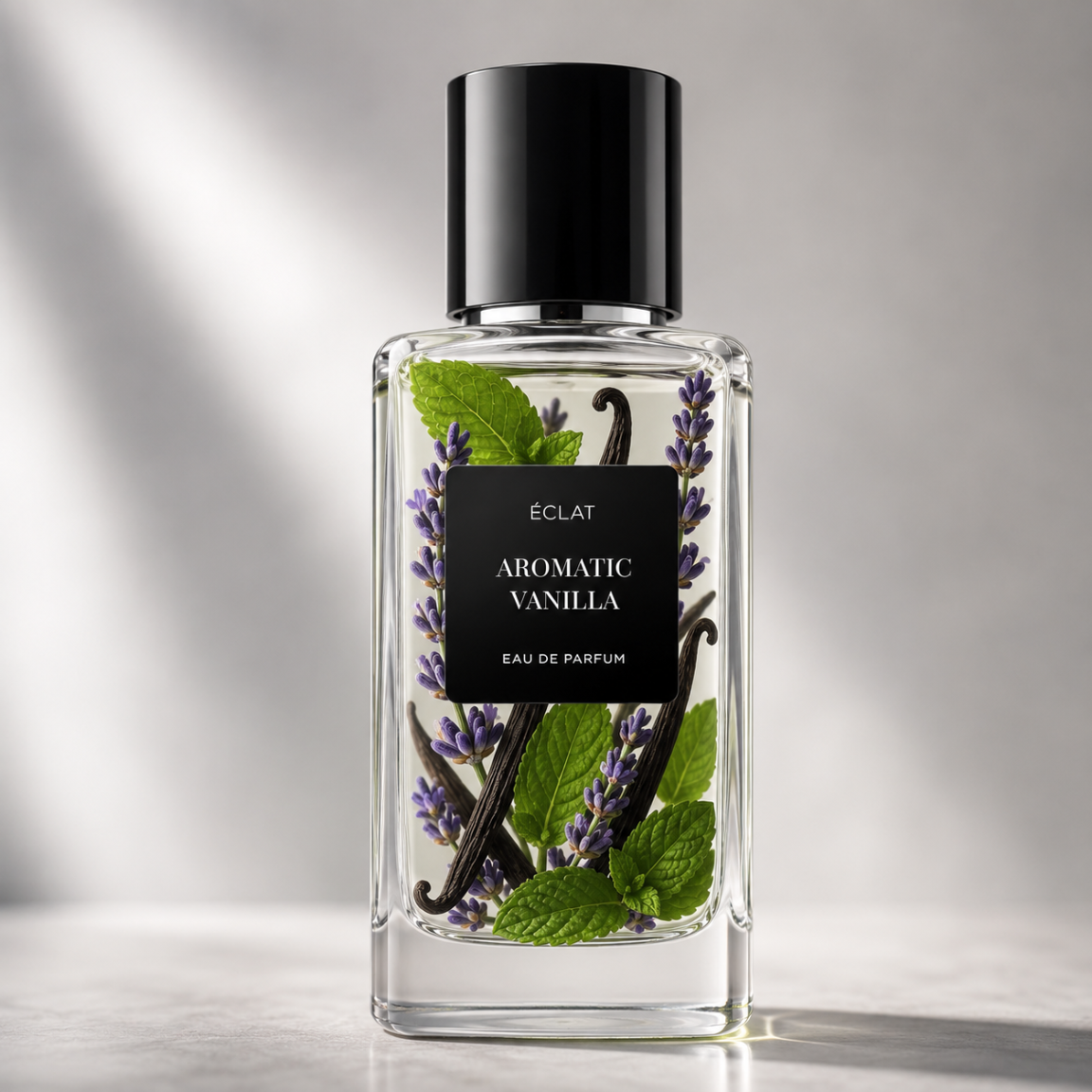 Eleganter Glasflakon von ÉCLAT Aromatic Vanilla mit schwarzem Etikett, Lavendelzweigen, Vanilleschoten und Minzblättern im Inneren.