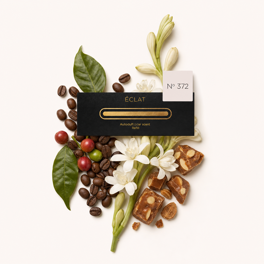 Ein Arrangement aus Kaffeebohnen, grünen Blättern, weißen Blüten, Karamellstücken und einer schwarzen ÉCLAT 372 Verschlusskappe mit Etikett.
