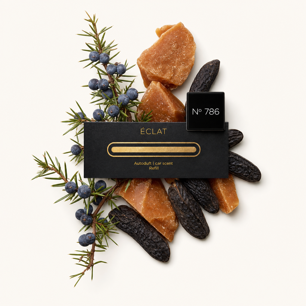 Ein Arrangement aus braunen Harzstücken, getrockneten Tonkabohnen und Wacholderbeeren umgibt eine schwarze Verschlusskappe mit goldenem ÉCLAT-Etikett.