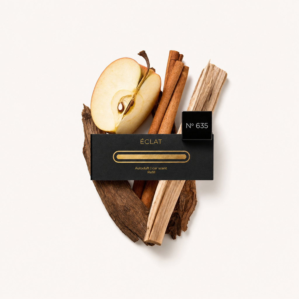 Ein Stillleben-Arrangement aus einer Apfelscheibe, Zimtstangen und Holzstücken, mit der schwarzen ÉCLAT-Verschlusskappe beschriftet „N° 635“ obenauf.