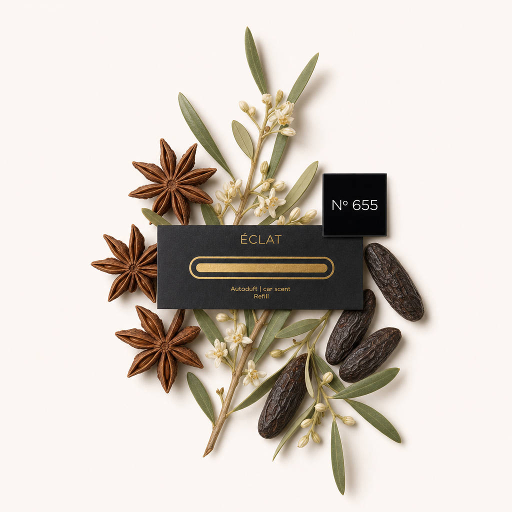 Ein Arrangement aus Sternanis, weißen Blüten, Oliven und Tonkabohnen umgibt eine schwarze ÉCLAT-Kappe mit goldakzentuiertem Etikett für Autoduft-Nachfüllung Nr. 655.