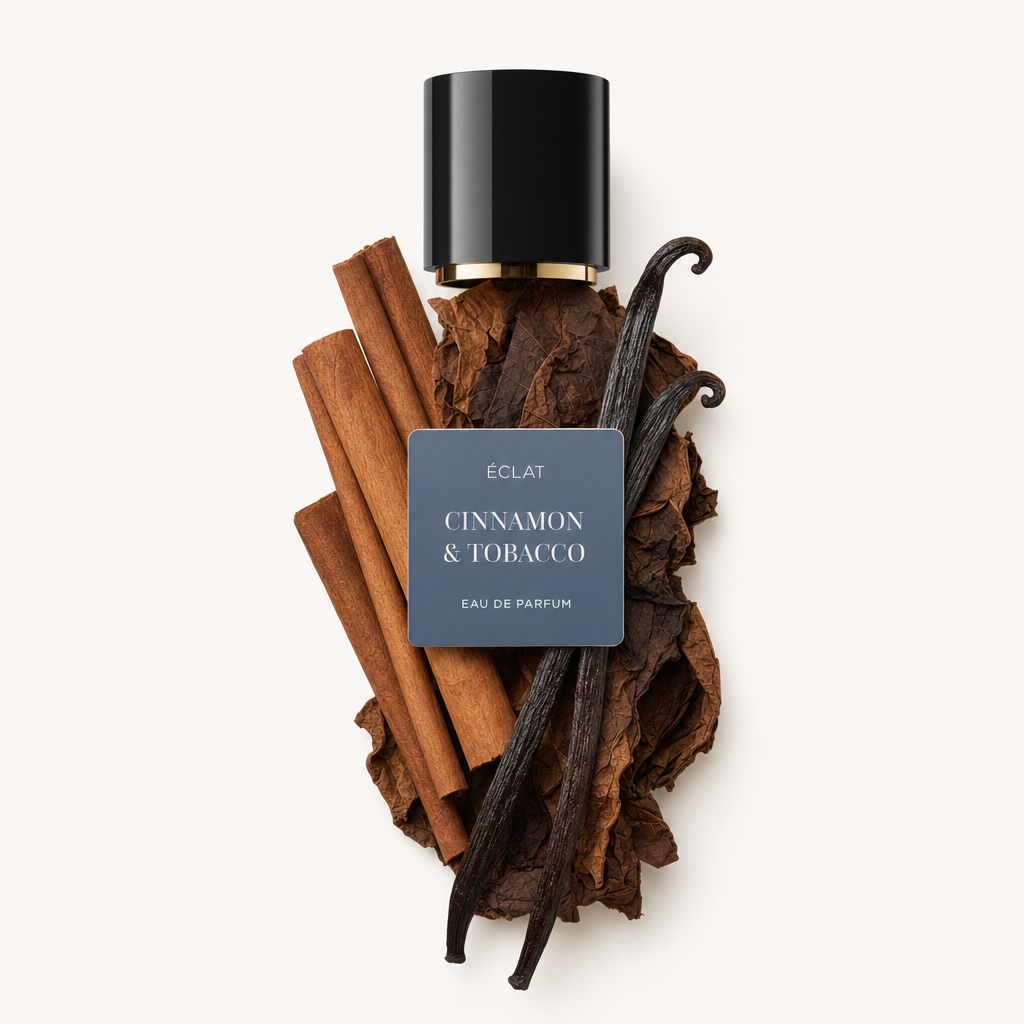 Ein Arrangement aus Zimtstangen, Tabakblättern und Vanilleschoten umgibt eine schwarze Verschlusskappe mit dem Etikett ÉCLAT Cinnamon & Tobacco.