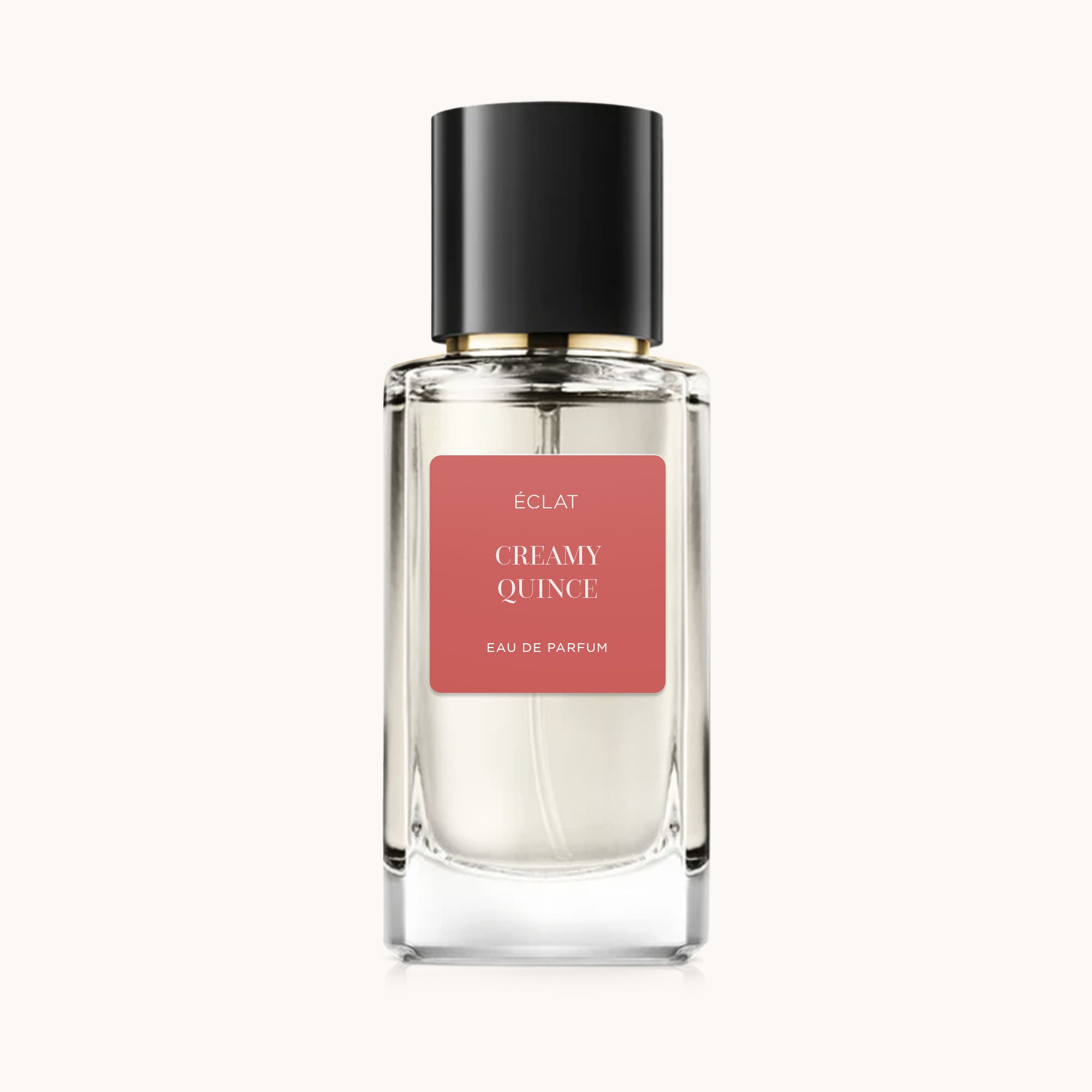 ÉCLAT Creamy Quince in einem facettierten Glasflakon mit schwarzem Verschluss und korallenfarbenem Etikett.
