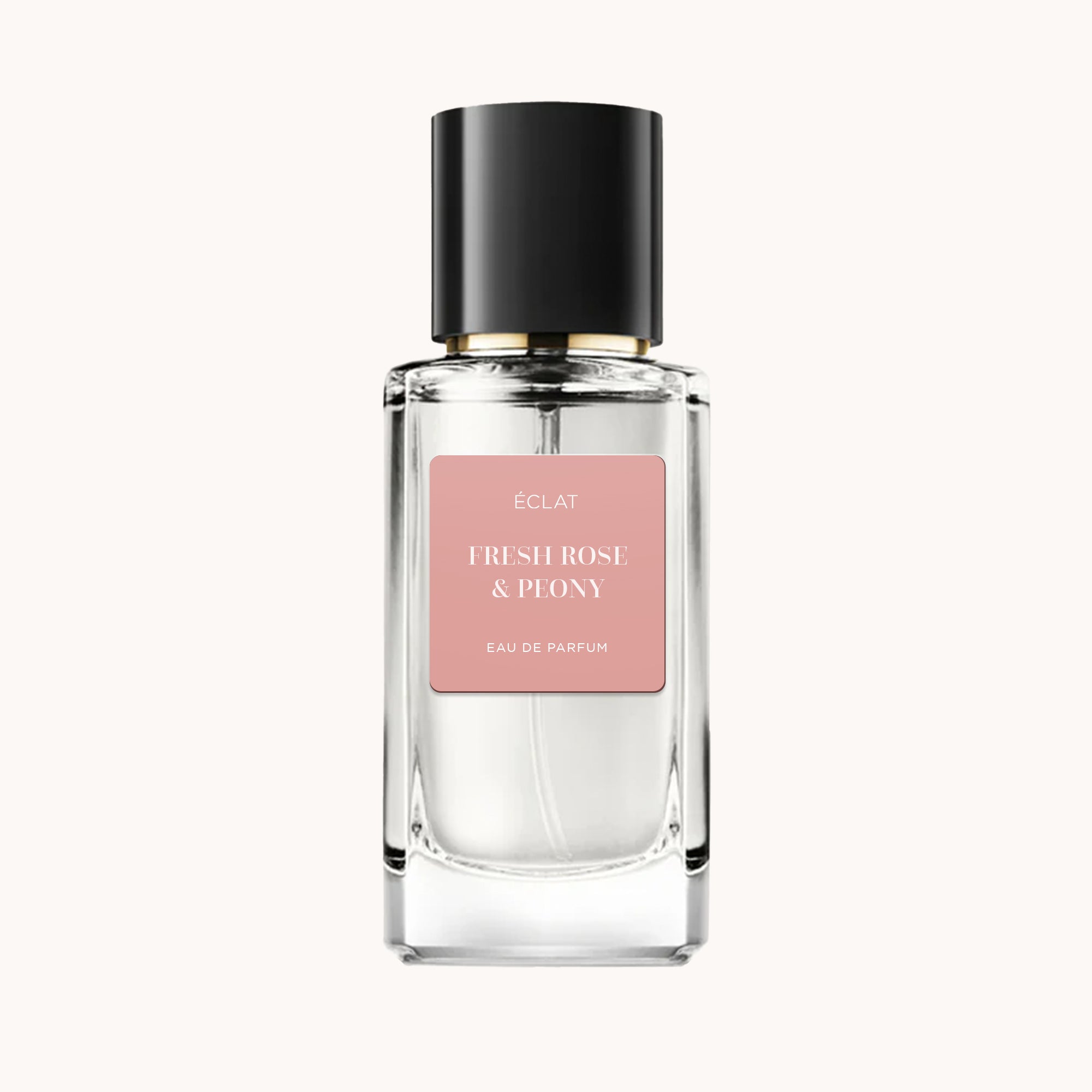Ein facettierter Glasflakon von ÉCLAT Fresh Rose & Peony mit mattem rosa Etikett und schwarzem Deckel.