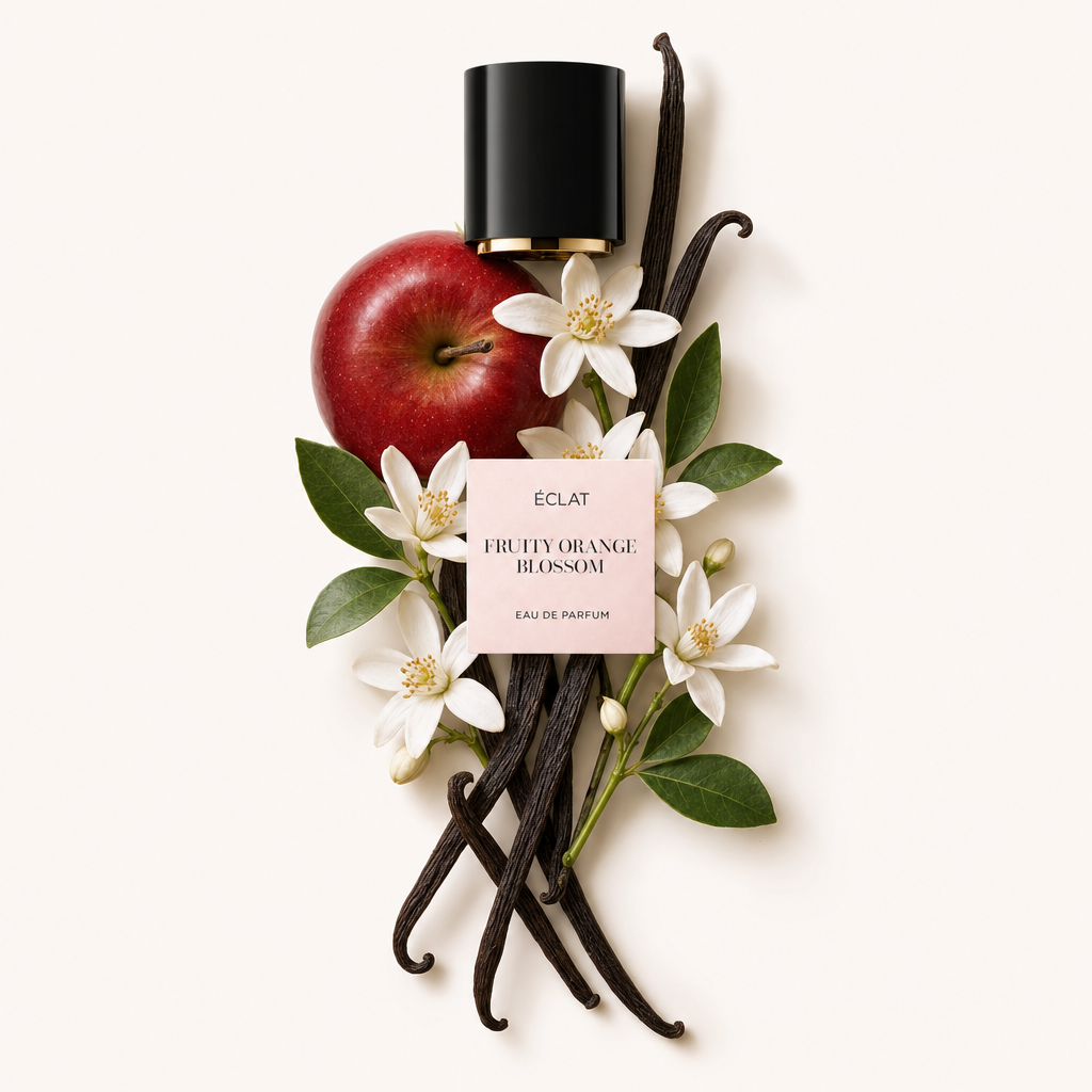 Ein kunstvolles Arrangement aus einem roten Apfel, weißen Orangenblüten und Vanilleschoten umgibt die schwarze Kappe mit ÉCLAT Fruity Orange Blossom Etikett.