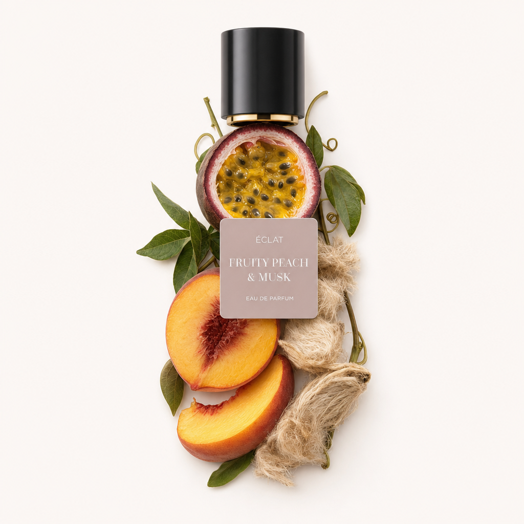 Ein Arrangement aus frischen Pfirsichscheiben, Passionsfrucht und Moschussamen mit grünen Blättern, unter einer schwarzen Kappe mit ÉCLAT Fruity Peach & Musk Etikett.