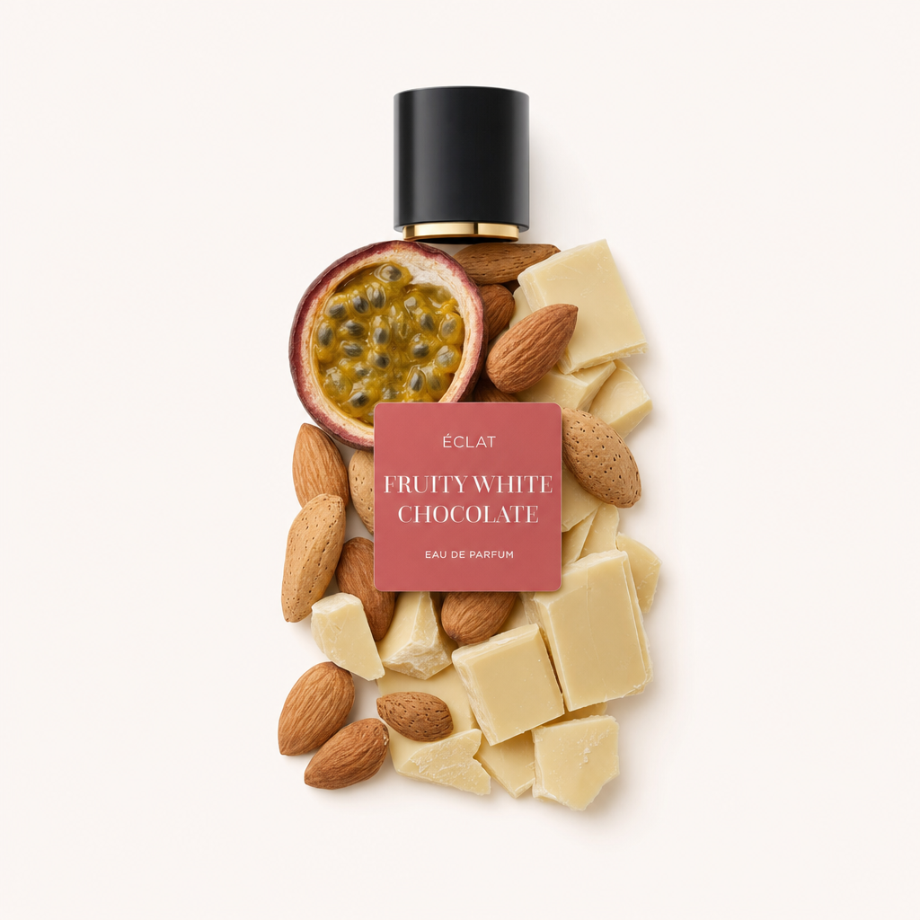 Ein kunstvolles Arrangement aus einer halbierten Passionsfrucht, ganzen Mandeln und Stücken cremiger weißer Schokolade unter einer schwarzen Verschlusskappe mit Etikett für ÉCLAT Fruity White Chocolate.