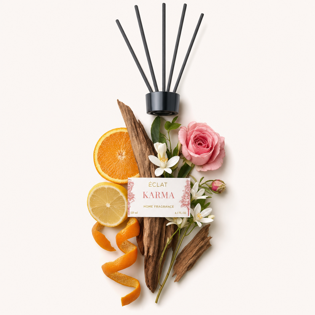 Ein Arrangement aus Orangen- und Zitronenscheiben, Holz, weißen Blüten und einer rosa Rose unter einer schwarzen Kappe mit dem ÉCLAT Karma-Label.