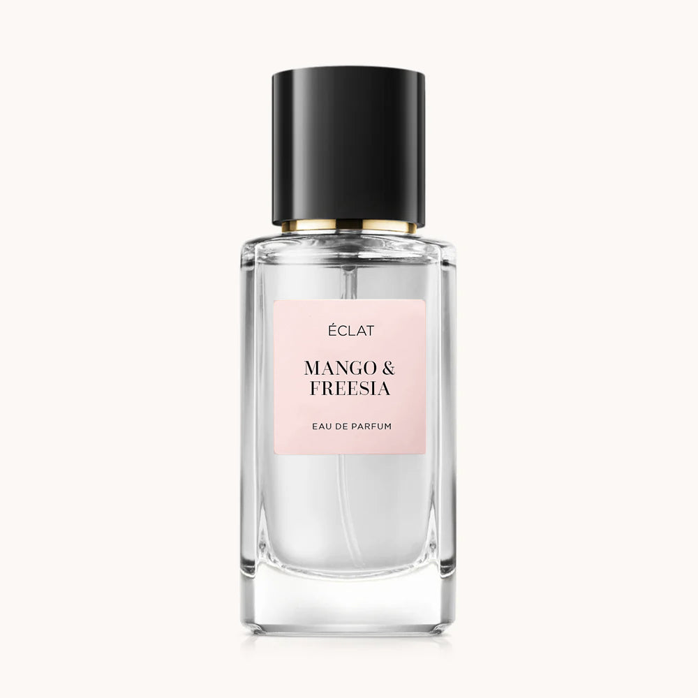 Klarer Glasflakon von ÉCLAT Mango & Freesia mit schwarzer Kappe und rosa Etikett.