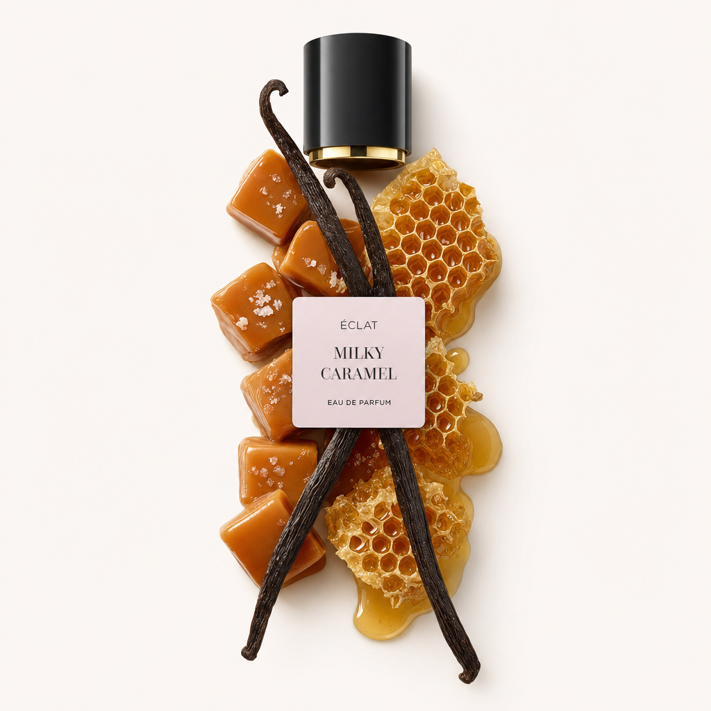 Ein Arrangement aus Karamellwürfeln, Vanilleschoten und Honigwaben unter einer schwarzen Kappe mit einem rosa Etikett von ÉCLAT Milky Caramel.