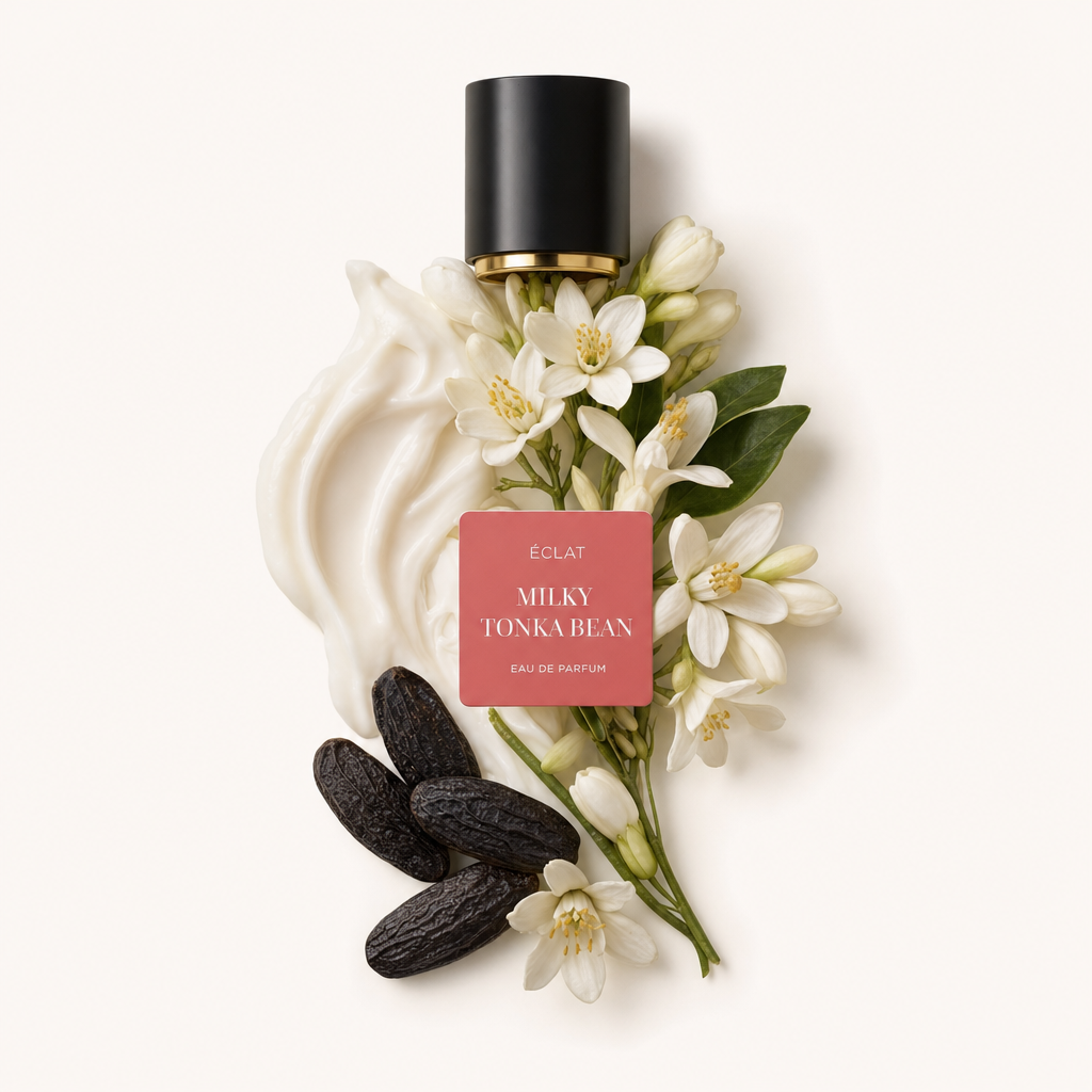 Ein Arrangement aus cremigen Schwüngen, Tonkabohnen und zarten weißen Blüten, mit einer schwarzen Kappe und Etikett für ÉCLAT Milky Tonka Bean.