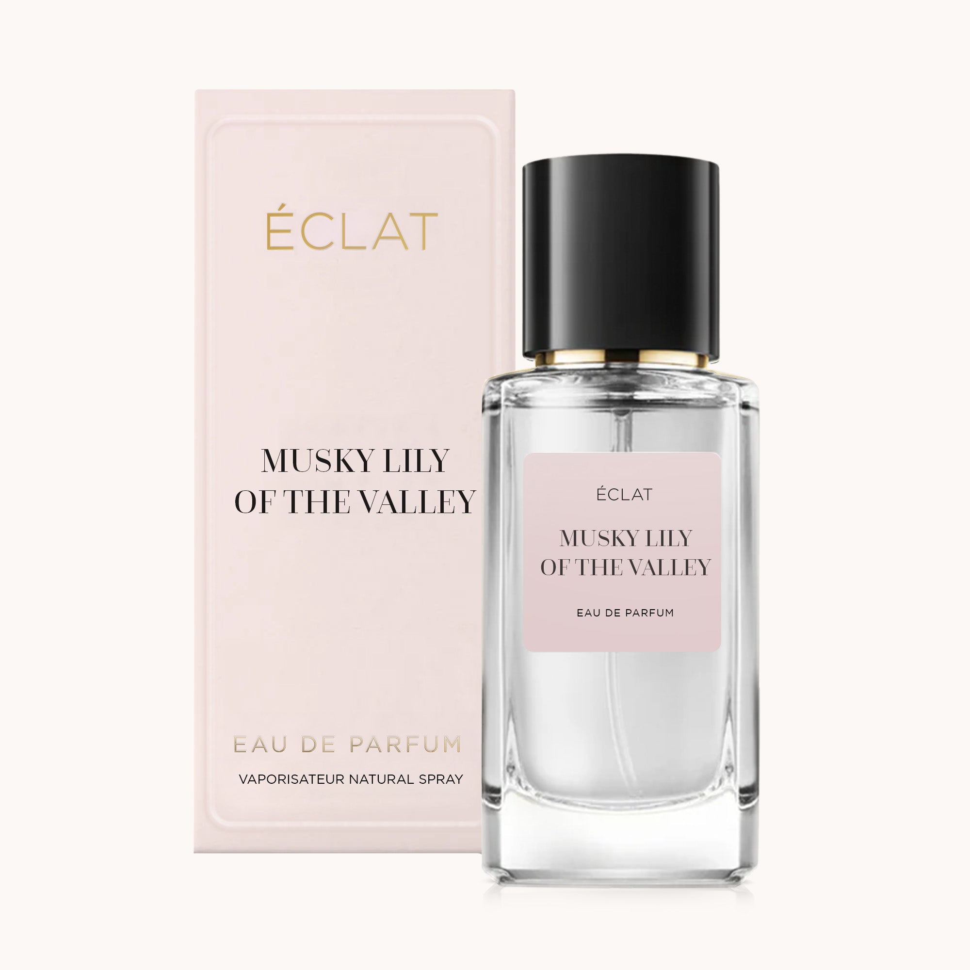 Ein facettierter Glasflakon von ÉCLAT Musky Lily of the Valley mit schwarzer Kappe, begleitet von einer hellrosa Schachtel.