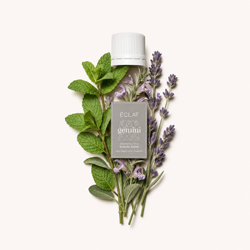 Ein Arrangement aus frischen Minz- und Lavendelzweigen umgibt eine weiße Kappe mit Etikett und präsentiert die Essenz von ÉCLAT Natural Oil Blend - Zodiac Sign Gemini.