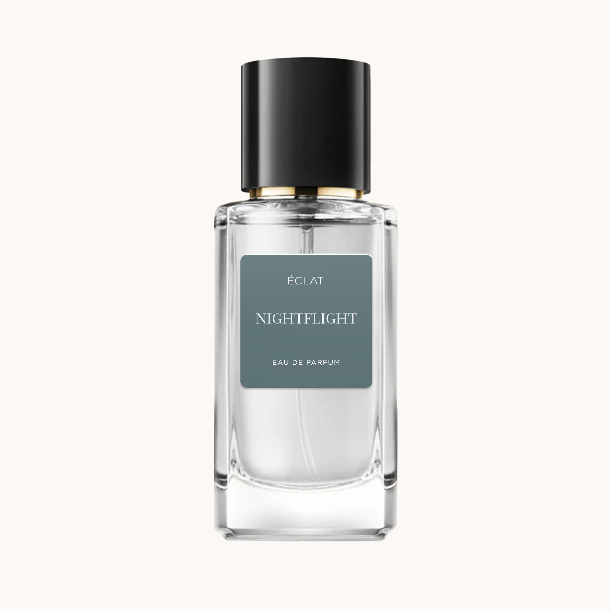 Ein facettierter Glasflakon von ÉCLAT Nightflight mit elegantem schwarzem Verschluss und mattem grauem Etikett.