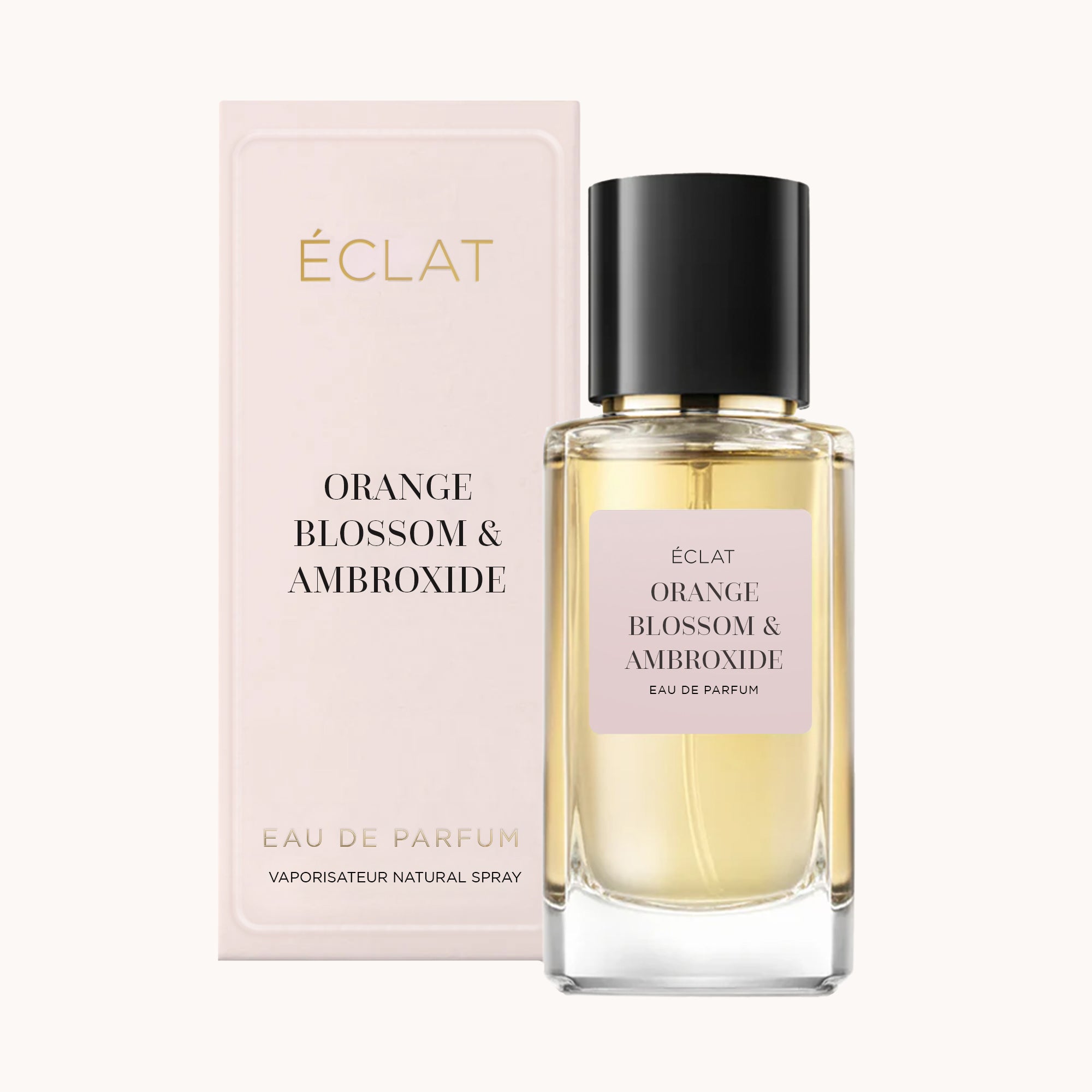 Elegantes ÉCLAT Orange Blossom & Ambroxide Parfum mit facettiertem Glasflakon und schwarzem Verschluss, begleitet von einer pastellrosa Box.
