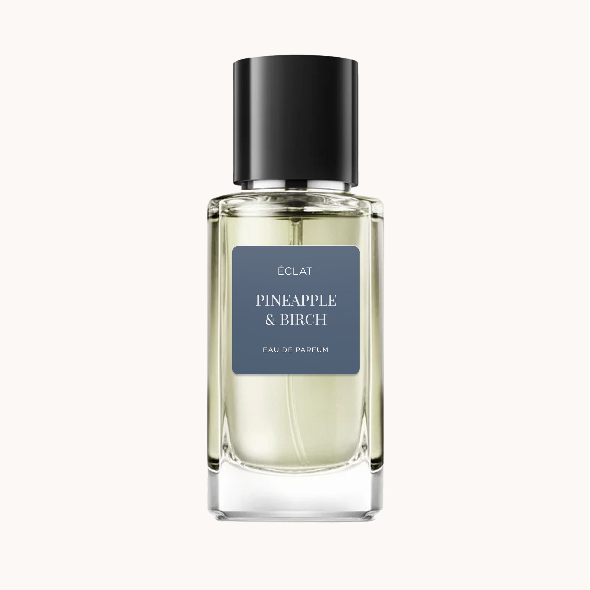 Der Duft ÉCLAT Pineapple & Birch in einem klaren Glasflakon mit schwarzem Verschluss und dunklem Etikett.