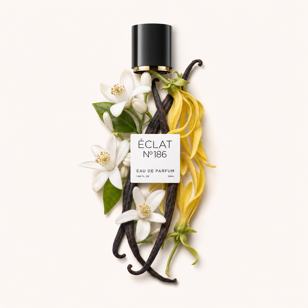 Ein Arrangement aus weißen Orangenblüten und gelben Ylang-Ylang-Blütenblättern, akzentuiert durch dunkle Vanilleschoten, umrahmt die schwarze Kappe mit einem Etikett von ÉCLAT Powdery Orange Blossom.