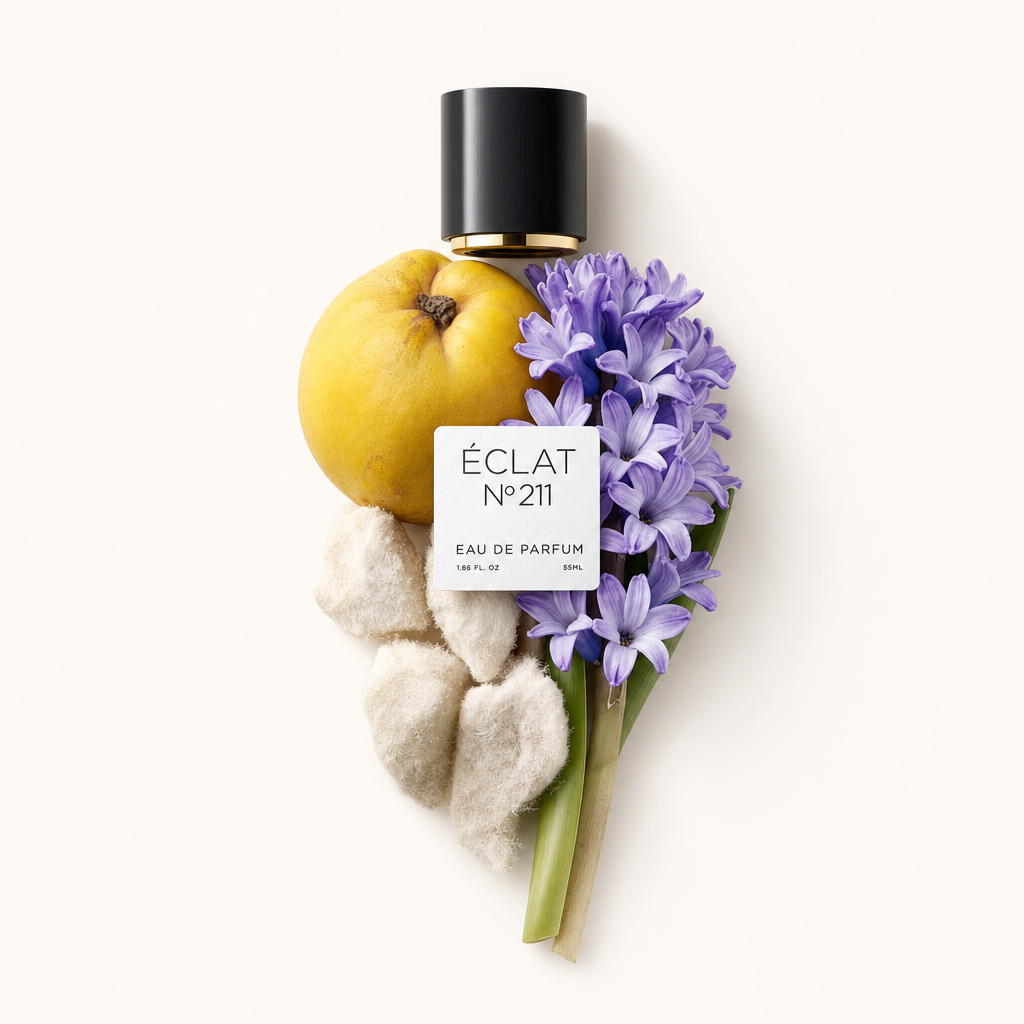 Ein Arrangement aus Quitte, violetten Hyazinthen und weichen Elementen umgibt eine schwarze Kappe mit ÉCLAT-Etikett.