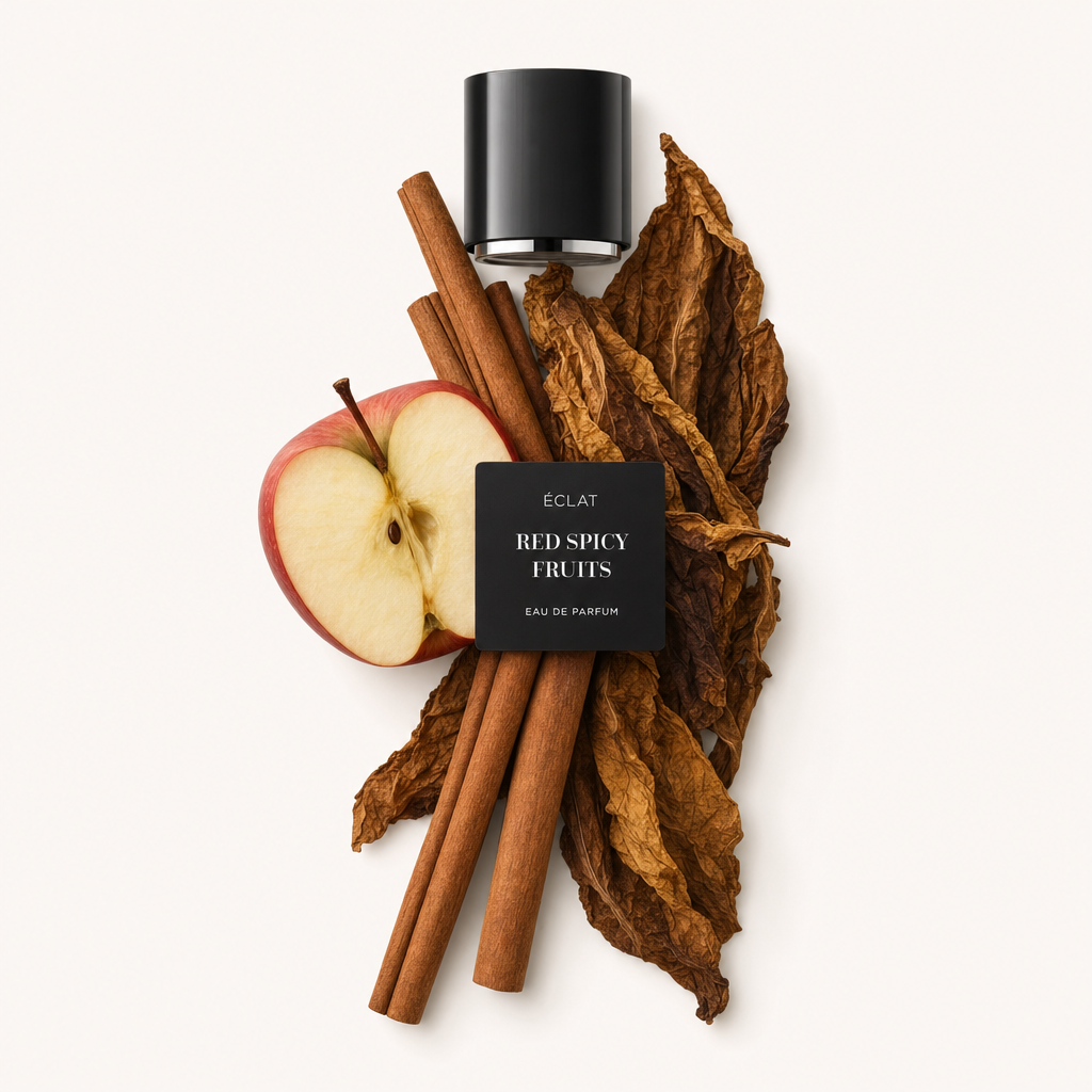 Ein Arrangement aus Zimtstangen, einem halbierten roten Apfel und großen getrockneten Tabakblättern umgibt die schwarze Kappe mit Etikett von ÉCLAT Red Spicy Fruits.