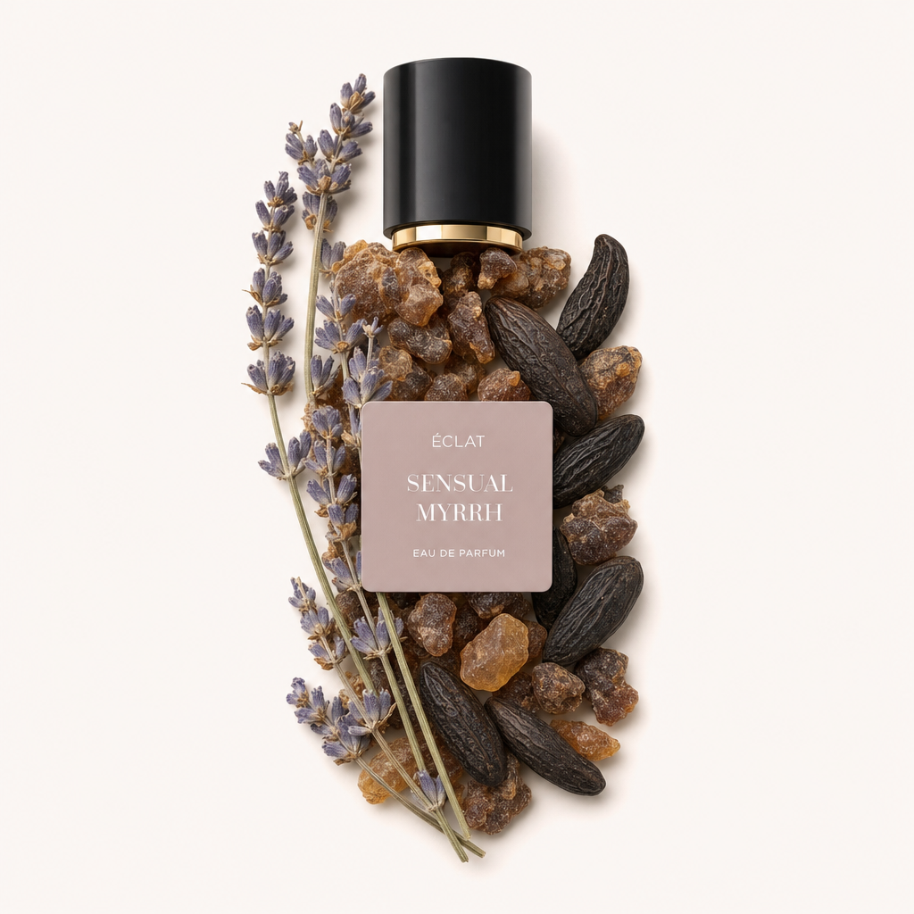 Ein Arrangement aus Lavendelzweigen, Myrrhenharz und Tonkabohnen umgibt eine schwarze Kappe mit goldenem Rand und einem ÉCLAT Sensual Myrrh Etikett.