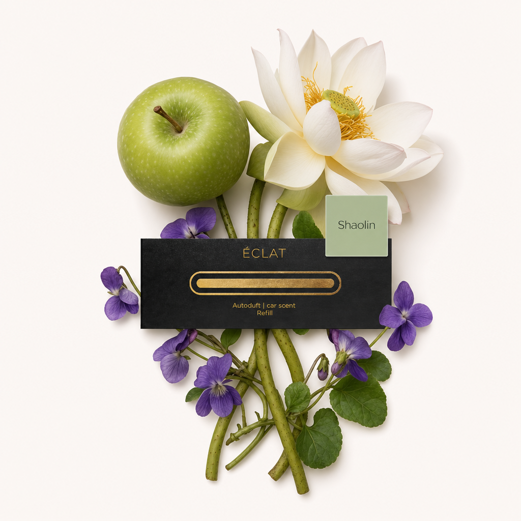 Ein Arrangement aus grünem Apfel, weißer Lotusblume und violetten Veilchen umgibt eine schwarze ÉCLAT-Kappe mit der Aufschrift 'Shaolin'.