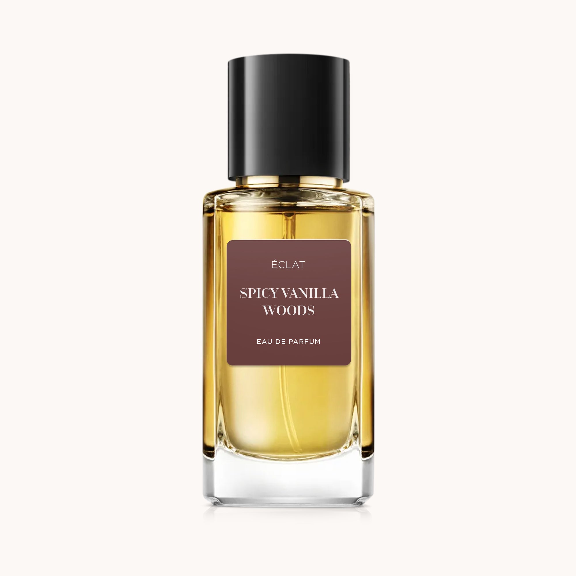 ÉCLAT Spicy Vanilla Woods in einem klaren Glasflakon mit schwarzem Verschluss und braunem Etikett.