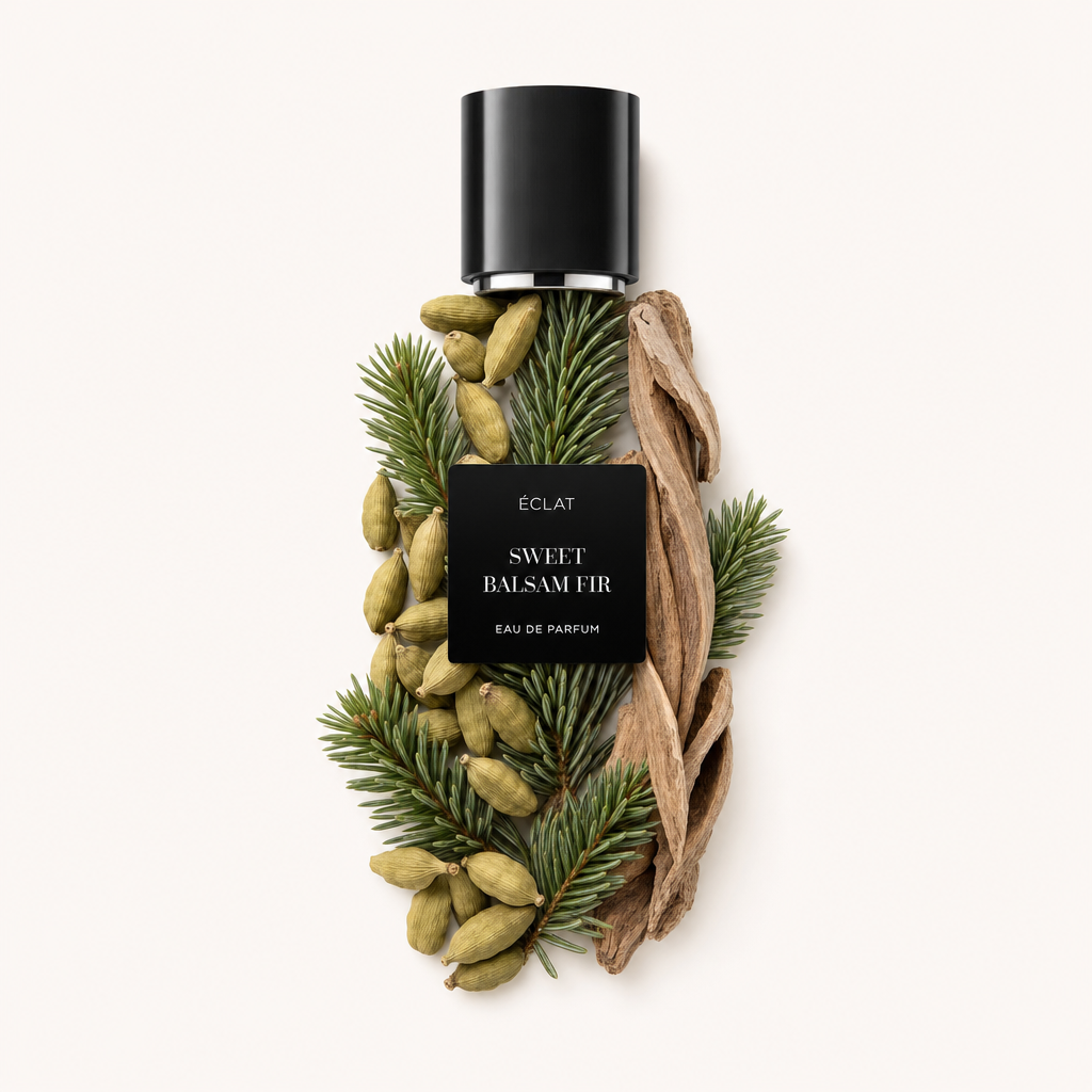 Ein Arrangement von Balsamtannenzweigen, Kardamomkapseln und Holzspänen umgibt eine schwarze Kappe mit ÉCLAT Sweet Balsam Fir Etikett.