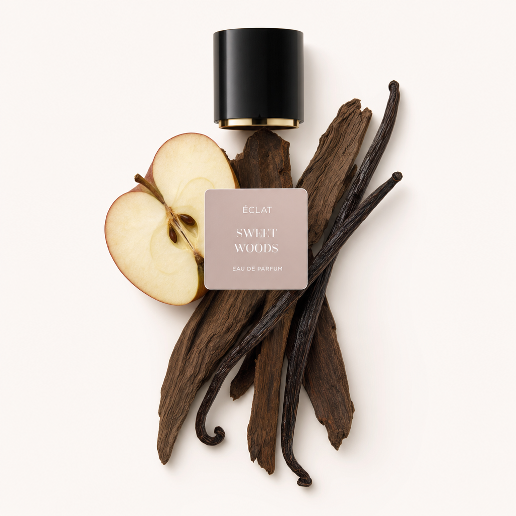 Ein Arrangement aus Apfelscheiben, Vanilleschoten und Holzstäben bildet eine natürliche Komposition unter dem ÉCLAT Sweet Woods Etikett und der originalen schwarzen Verschlusskappe.