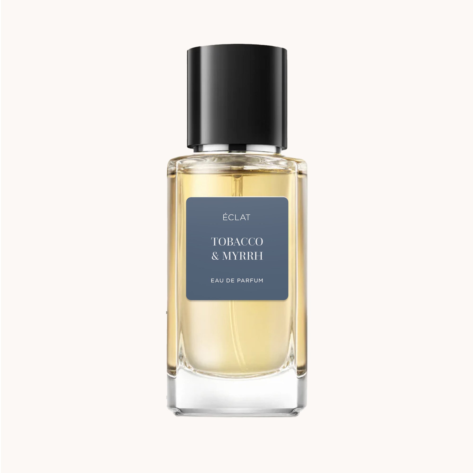 ÉCLAT Tobacco & Myrrh in einem klaren Glasflakon mit schwarzer Kappe und mattem blauem Etikett.