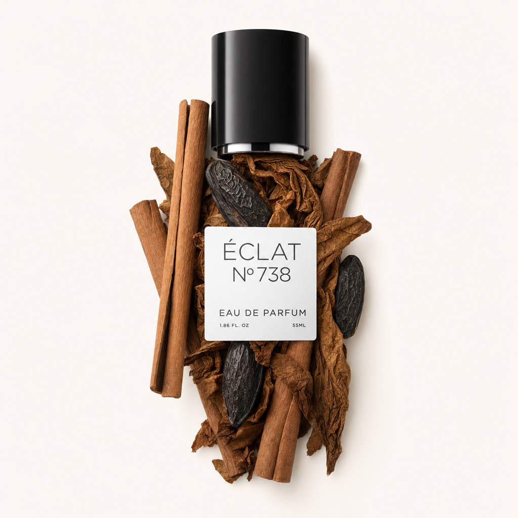 Eine schwarze Verschlusskappe mit Etikett ÉCLAT Tonka Bean & Cinnamon ruht auf einem Arrangement aus Zimtstangen und Tonkabohnen.