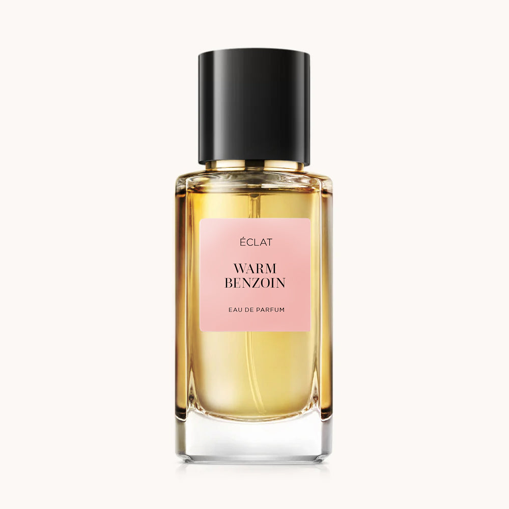 Facettierter Glasflakon von ÉCLAT Warm Benzoin mit schwarzem Verschluss und rosa Etikett.